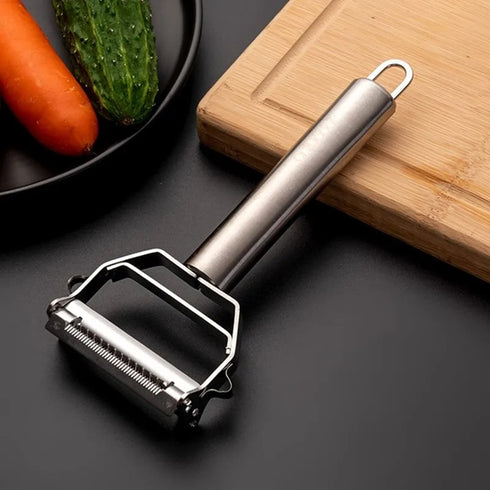 Close-up of stainless steel peeler showing sharp dual blades and ergonomic handle.